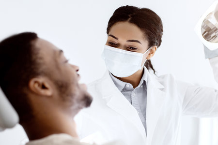 Dentistry Concept. Young Black Patient Guy Having Check Up With Dentist Womanの写真素材
