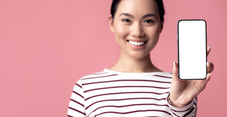Online Offer. Smartphone With White Screen In Hands Of Smiling Asian Womanの写真素材