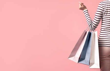 Shopping Concept. Rear View Of Young Female Holding Shopper Bags, Cropped Shotの写真素材