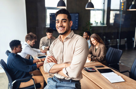 Successful person. Confident arab businessman leaning on desk in office, posing with folded arms and...