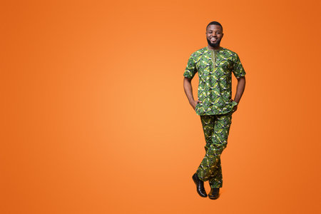 Handsome black man in traditional african clothes over yellow backgroundの写真素材
