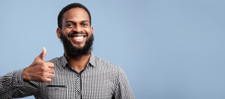Happy black guy gesturing thumbs up and smilingの写真素材