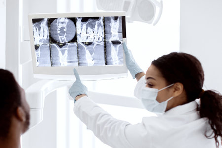 Stomatologist Lady Showing Teeth Xray Picture On Digital Monitor To Male Patientの写真素材