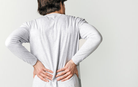Body ache and kidneys pain. Man presses his hands to back