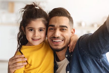 Happy Middle Eastern Father Taking Selfie With His Little Daughter At Homeの写真素材