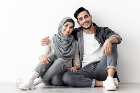 Happy young muslim couple posing in empty apartmentの写真素材