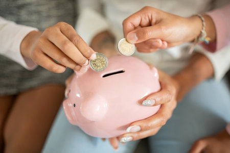 Family members teach children about saving money with a piggy bankの写真素材