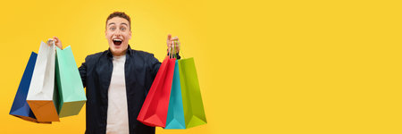 Happy young man going shopping, holding bags and looking excited