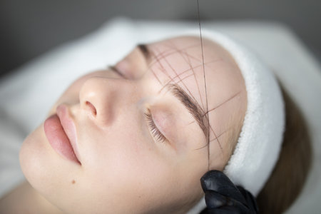 Expert brow shaping procedure at beauty salon for lasting eleganceの写真素材