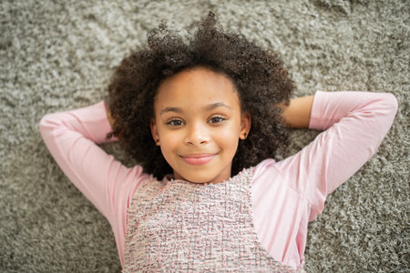 Happy girl relaxing on a cozy floor at home with love and warmthの写真素材