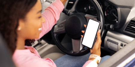 Happy black woman using smartphone with empty screen driving car