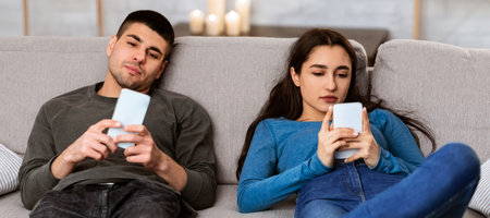 Couple using cell phones sitting on the couch