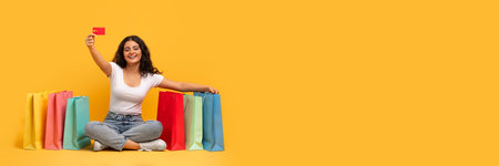 Cheerful young eastern lady with shopping bags and credit card