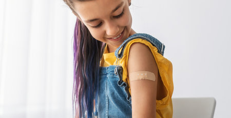 Happy Vaccinated Teen Girl Showing Shoulder After Shotの写真素材
