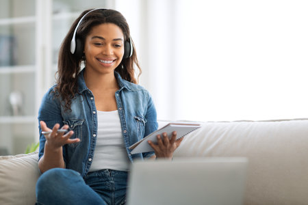 Young woman in denim jacket engaged in online conversation at home