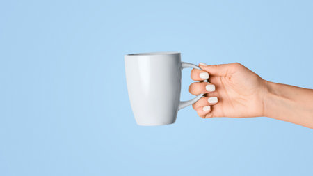 Closeup of young woman showing cup with hot beverage on pink background. Panoramaの写真素材
