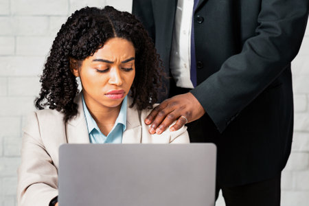Workplace harassment concept. Businessman using his job position to molest female employee at company officeの写真素材