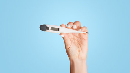 Closeup of millennial girl holding electronic thermometer on pink background