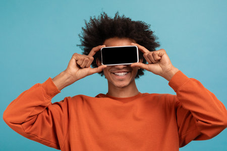 A young African American man with curly hair is smiling widelyの写真素材