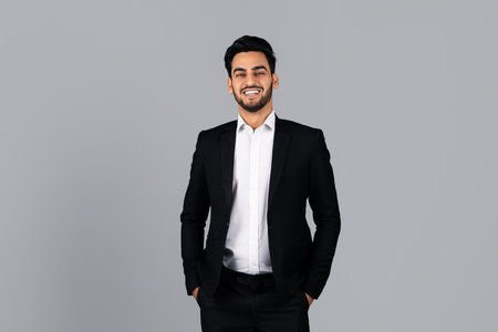 Confident Middle Eastern businessman smiling in studio setting during daylightの写真素材