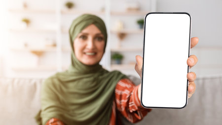 Happy Senior Muslim Woman Showing Smartphone Empty Screen Indoor, Panorama