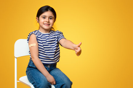 Kids Vaccination. Vaccinated Little Girl Gesturing Thumb Up After Covid-19 Vaccine Injectionの写真素材