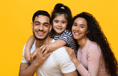 Portrait Of Cheerful Arab Family With Daughter Hugging And Smiling At Cameraの写真素材
