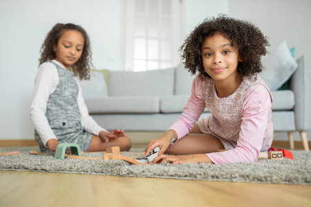 Sisters bond and get creative while playing with building blocksの写真素材