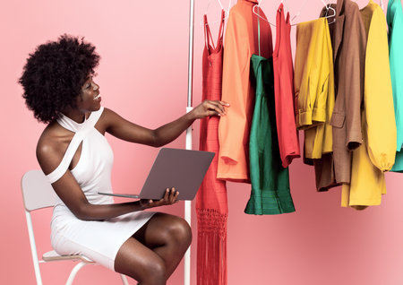 Black Female Buyer With Laptop Shopping Online Over Pink Backgroundの写真素材