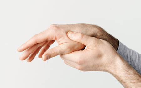 Fracture, injury or pain in arm. Man presses one hand with otherの写真素材