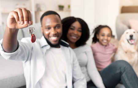 Happy black family showing keys of their new apartmentの写真素材