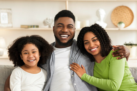 Happy Black Family Of Three Posing At Home, Embracing And Smilingの写真素材