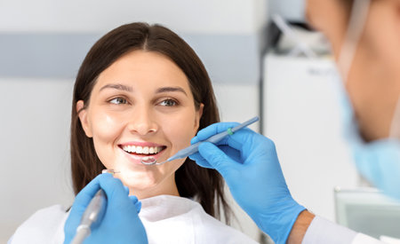 Smiling woman looking with trust at dentist during treatmentの写真素材