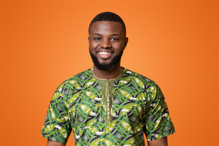 African man in green authentic clothes posing over yellow backgroundの写真素材