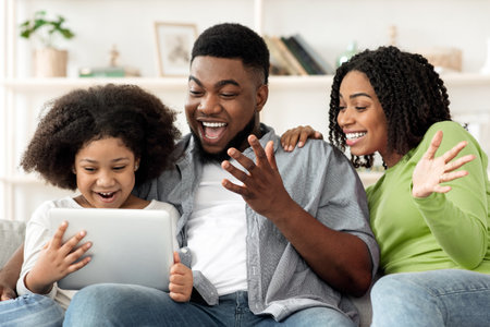 Cheerful African Family Having Fun With Digital Tablet At Homeの写真素材