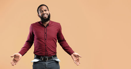 Portrait of black guy showing his empty pocketsの写真素材