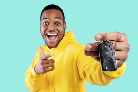 Excited Black Man Showing New Car Key On Blue Background