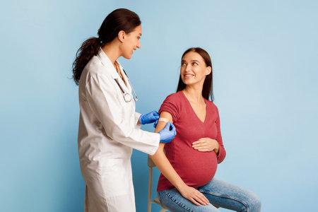Pregnant Female Patient Getting Vaccinated Against Coronavirus Over Blue Backgroundの写真素材