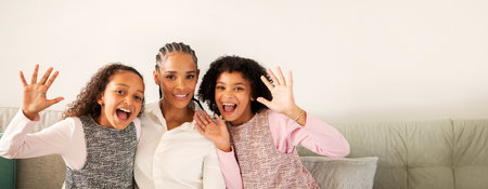 A joyful mother and her two daughters smiling together at homeの写真素材