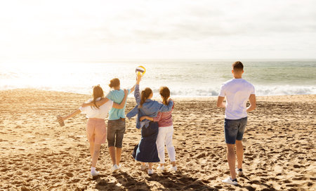 Friends enjoying a fun day at the beach while playing volleyball in summerの写真素材