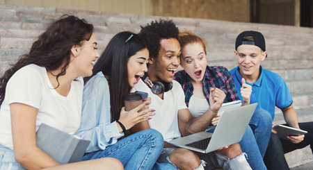 Emotional Teenage Students Looking Excited in Laptopの写真素材