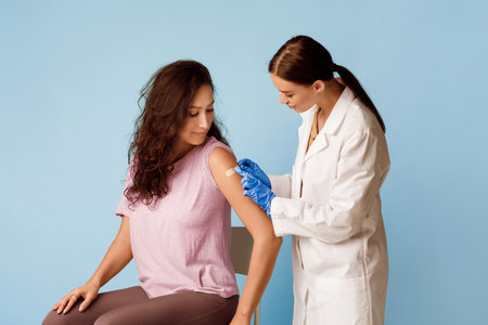 Healthcare professional applying bandage after vaccination, studio shotの写真素材