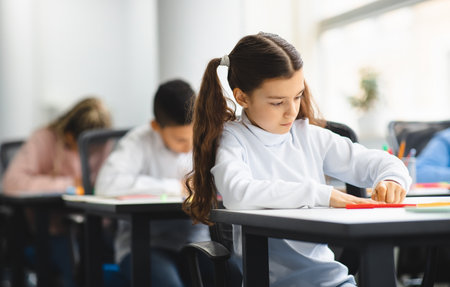 Student focused on work at desk in classroomの写真素材