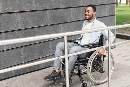 Accessible environment for people with special needs concept. Positive young black man in wheelchair...