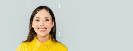 Facial recognition technology applied on a smiling individual in yellow attire