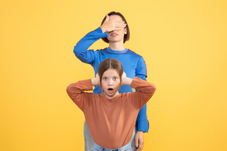 Mother and daughter share a playful moment with surprised expressionsの写真素材