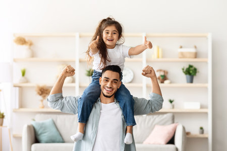 Playful middle-eastern father and daughter having fun at homeの写真素材