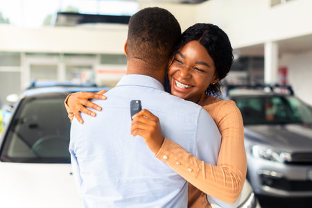 Best Present. Happy Black Woman Holding Car Key And Embracing Her Husbandの写真素材