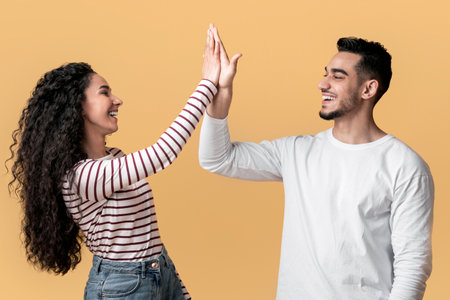 Portrait Of Happy Young Arab Couple Giving High Five To Each Otherの写真素材