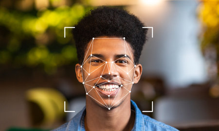 A young man is smiling while facial recognition technology scans his faceの写真素材